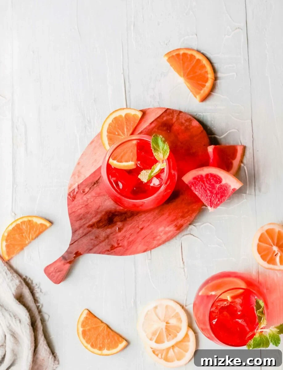 Sunkissed Citrus Sparkler 5 An Aperol Spritz, perfectly garnished with an orange slice, is placed on a round wooden cutting board, ready to be served.