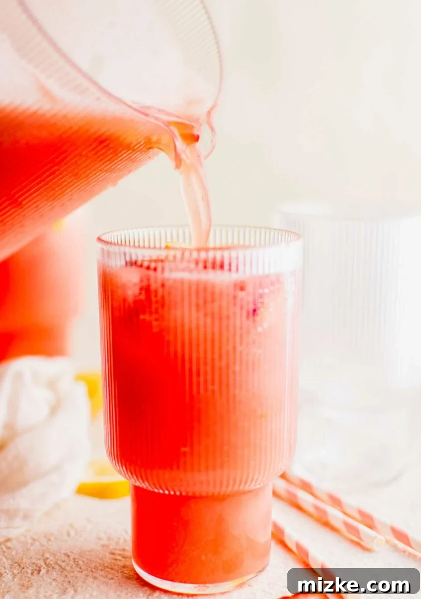 Zesty Summer Sips 2 Pink lemonade is being poured into a glass from a pitcher, showcasing its vibrant color and refreshing appeal.