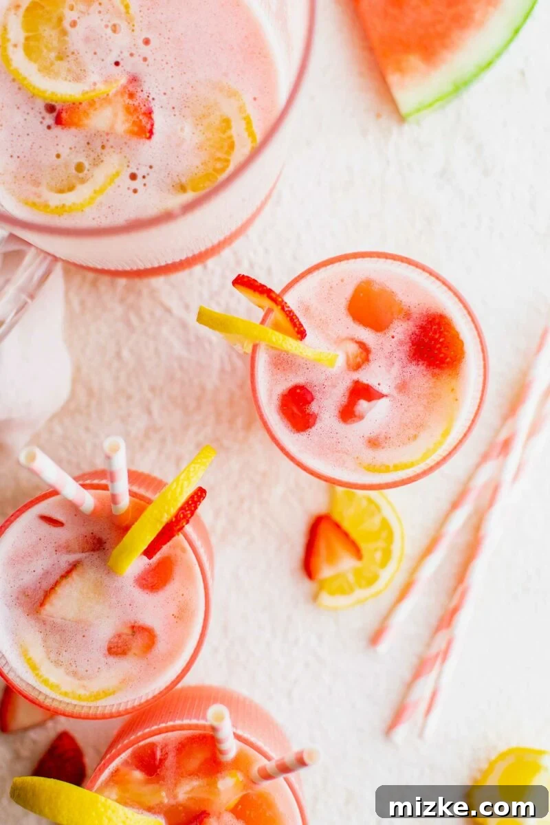 Zesty Summer Sips 5 A vibrant glass of pink summer lemonade, possibly with fresh fruit slices as garnish, invitingly presented.