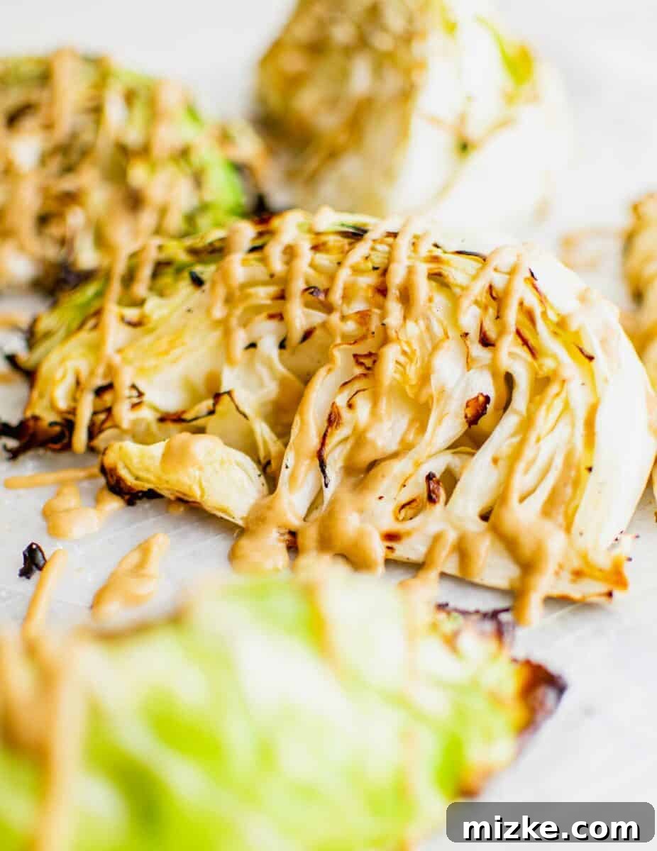 A piece of drizzled cabbage is very lightly charred. 