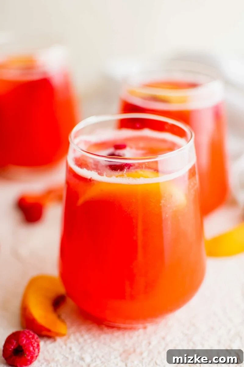 Cool Summer Delight 2 Several glasses of refreshing summer punch are arranged beautifully on a pristine white surface, garnished with fresh fruit.