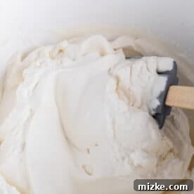 heavy cream mixture being mixed together with a silicone spatula