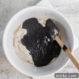black sesame paste added to a white bowl with the heavy cream