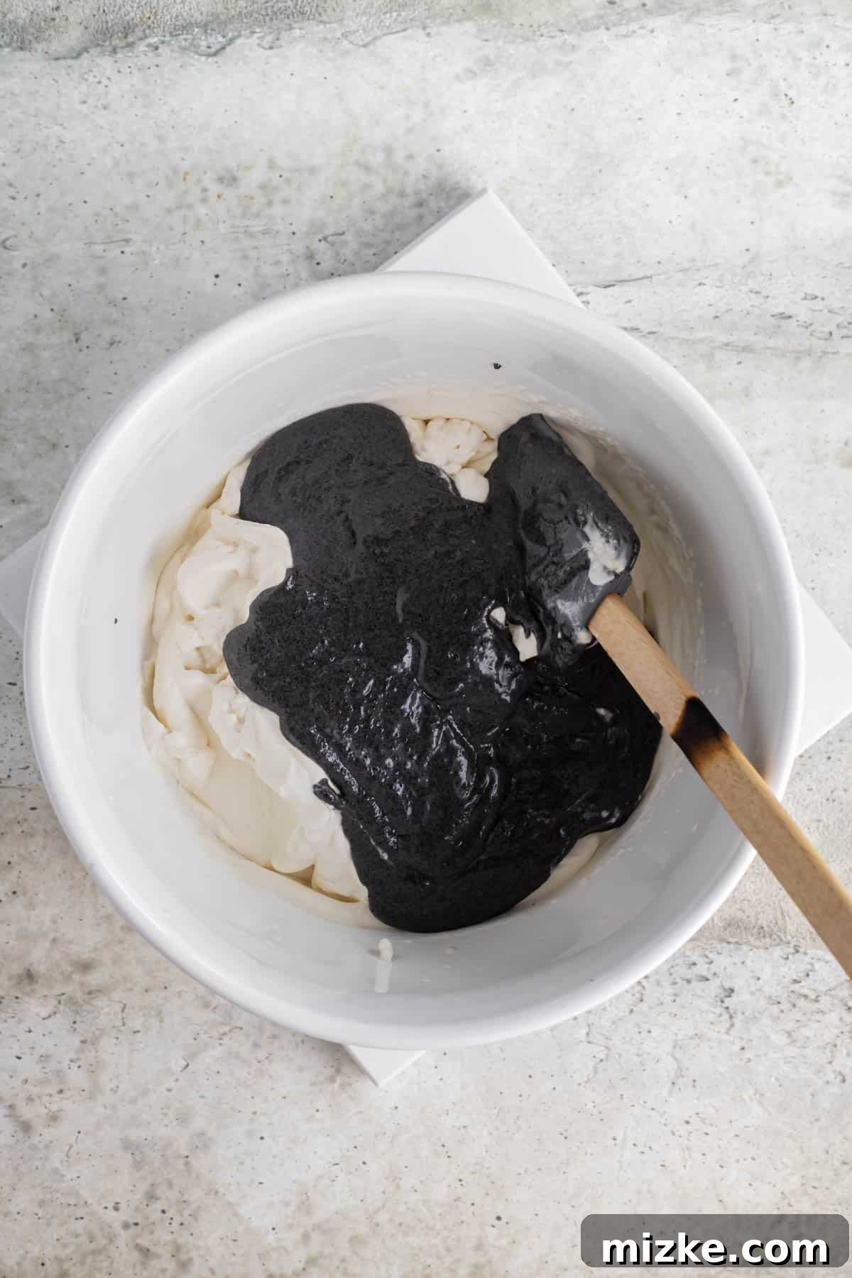 Midnight Sesame Dream 7 black sesame paste added to a white bowl with the heavy cream
