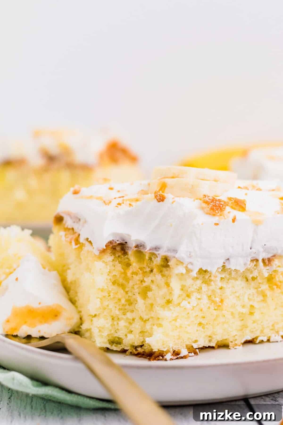 Ultimate Banana Pudding Poke Cake 3 A bite of cake has been removed by a fork.