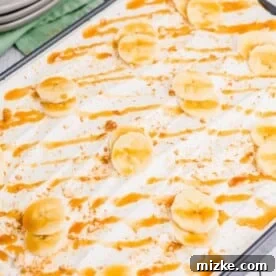 Ultimate Banana Pudding Poke Cake 7 Banana slices and caramel sauce top a whipped cream covered poke cake.
