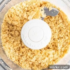 Crushed tortillas in the bowl of a food processor for the crust.
