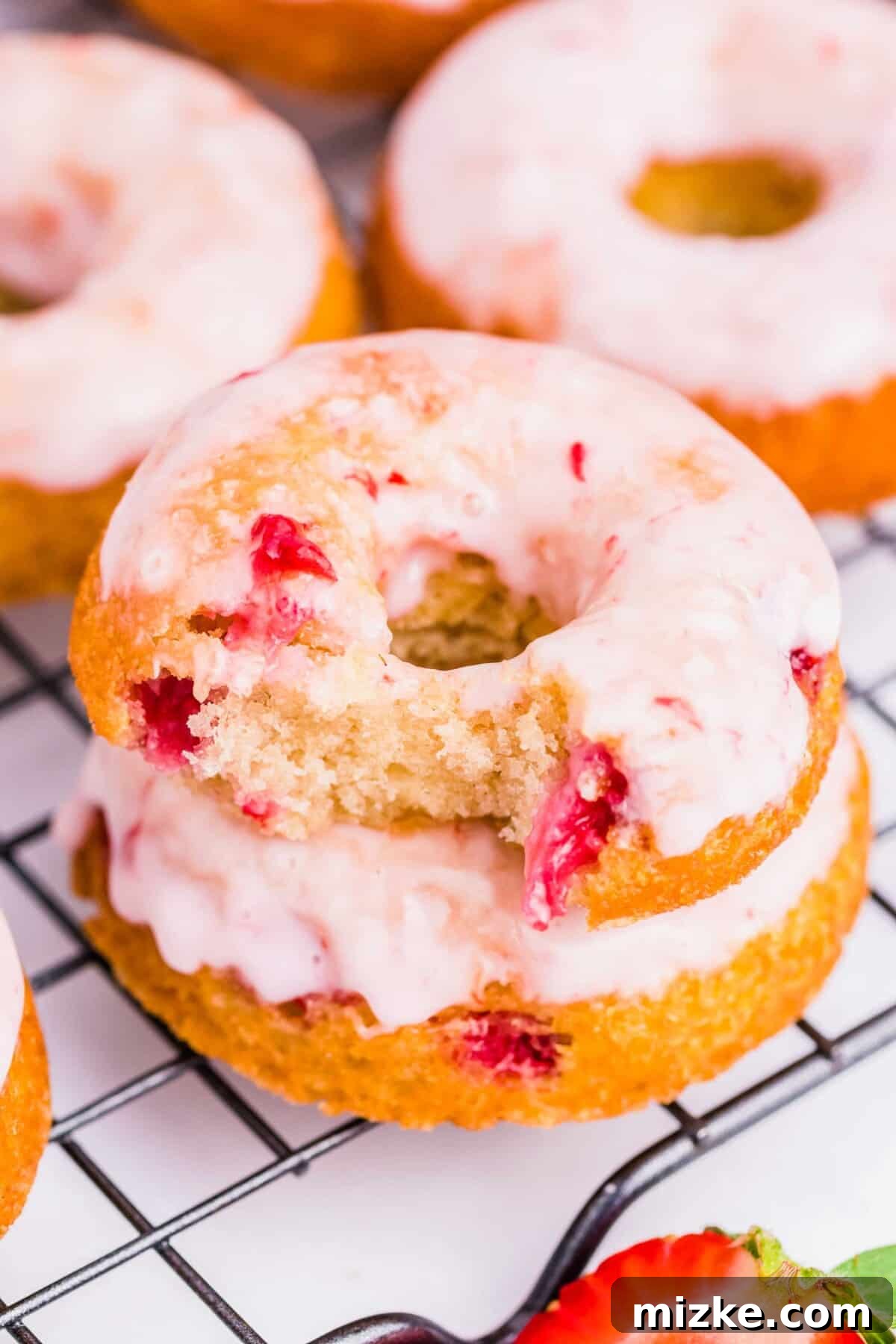 Strawberry Oven Donuts 2 Several perfectly glazed baked strawberry donuts arranged on a wire cooling rack, ready to be enjoyed.