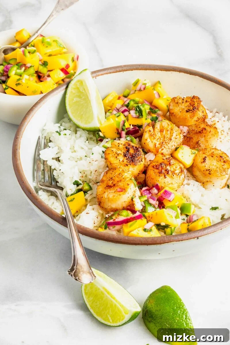 Seared Cajun Brown Butter Scallops 5 Fresh lime wedges are artfully arranged around the rim of a rice and scallop bowl, adding a vibrant touch of color.