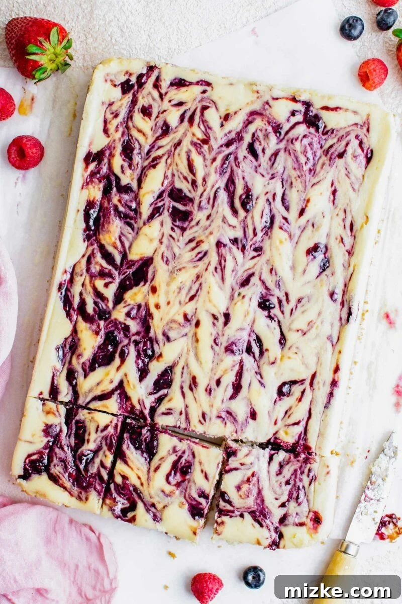 Vibrant Berry Cheesecake Squares 2 Three perfectly sliced Triple Berry Cheesecake Bars arranged on a white serving dish, showcasing the vibrant berry swirl and golden crust.