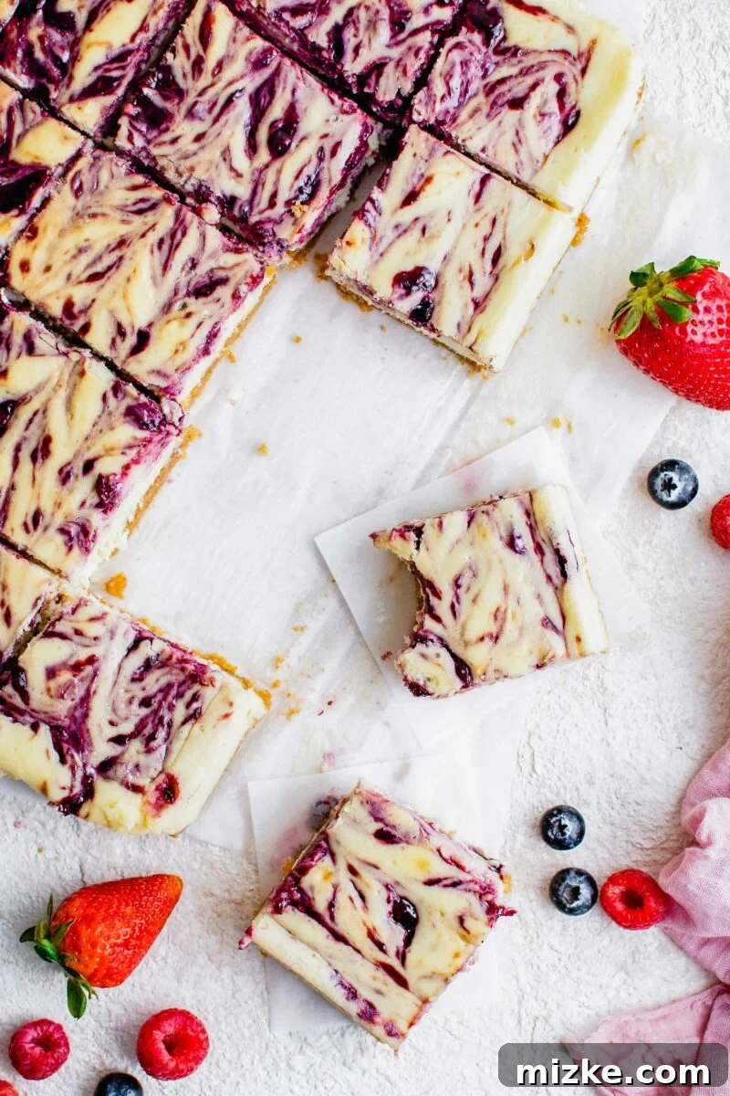 Vibrant Berry Cheesecake Squares 5 A close-up shot of a Triple Berry Cheesecake Bar with a bite taken out, revealing its creamy layers and berry goodness.