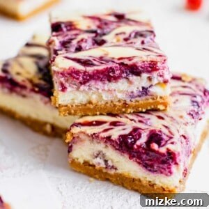Vibrant Berry Cheesecake Squares 8 A close-up of a finished Triple Berry Cheesecake Bar with a vibrant berry swirl and a golden graham cracker crust.