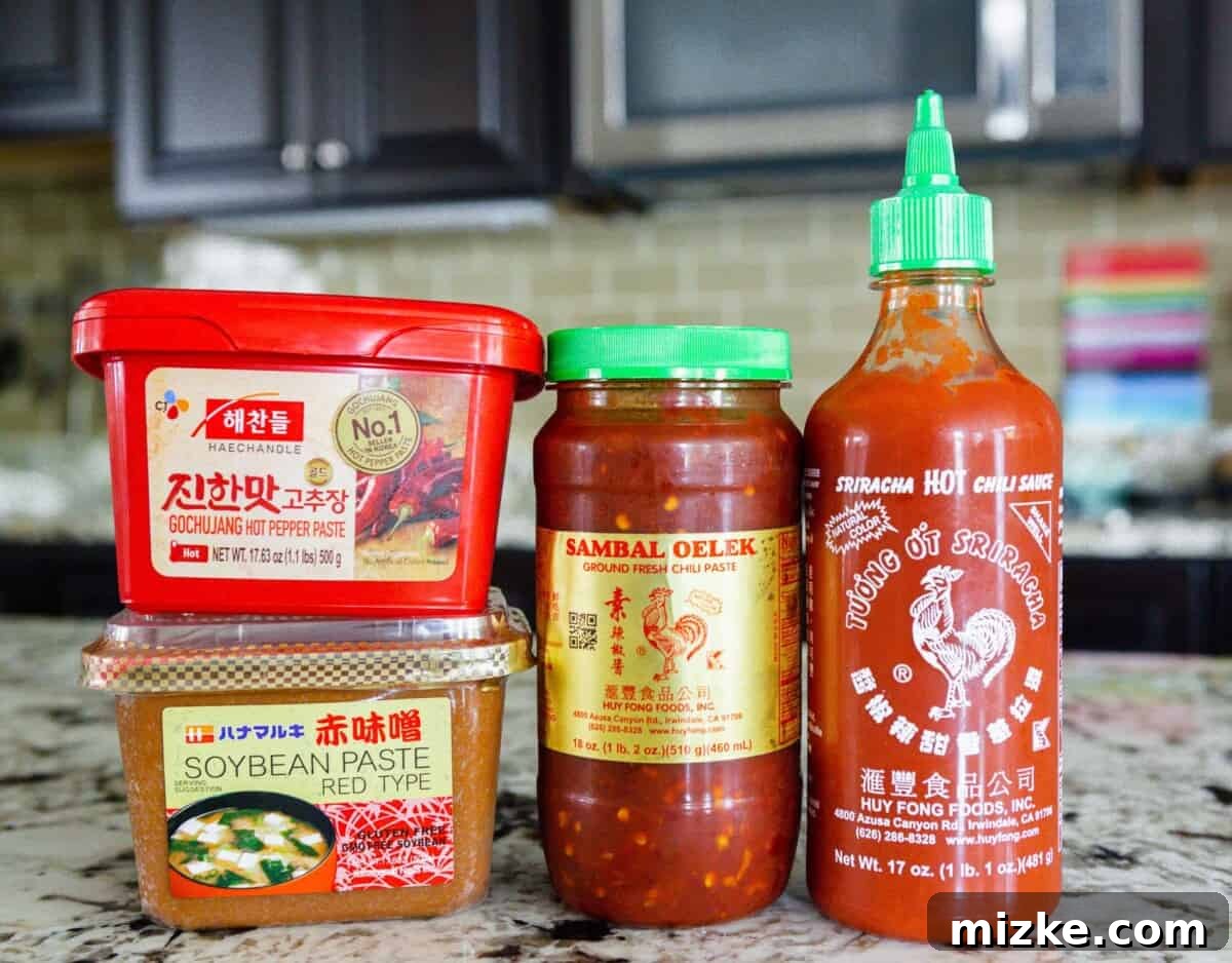 The Palette of Chinese Flavors 6 A vibrant display of gochujang, miso paste, sambal oelek, and sriracha, showcasing a range of fermented and spicy condiments.