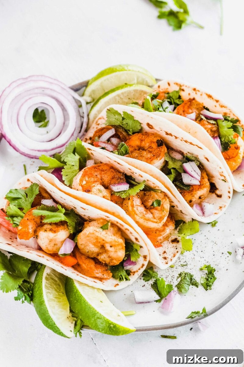 A beautifully plated serving of shrimp tacos, garnished with fresh toppings, ready to be enjoyed.