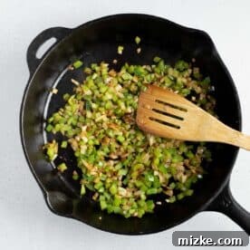 Crispy Air Fryer Beef Taquitos 13 green onions and onions in a cast iron skillet with a wooden spoon
