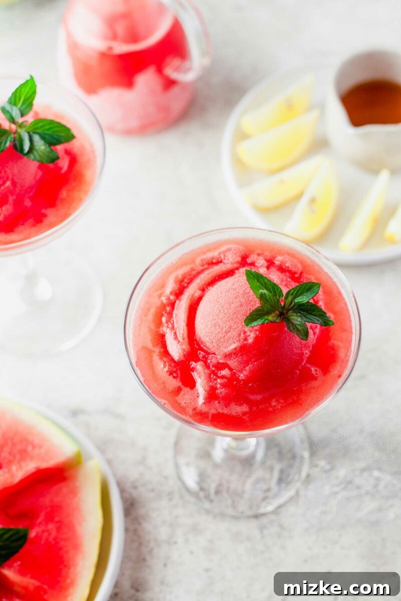 A tall glass is filled to the brim with glistening Watermelon Frosé, ready to be served.