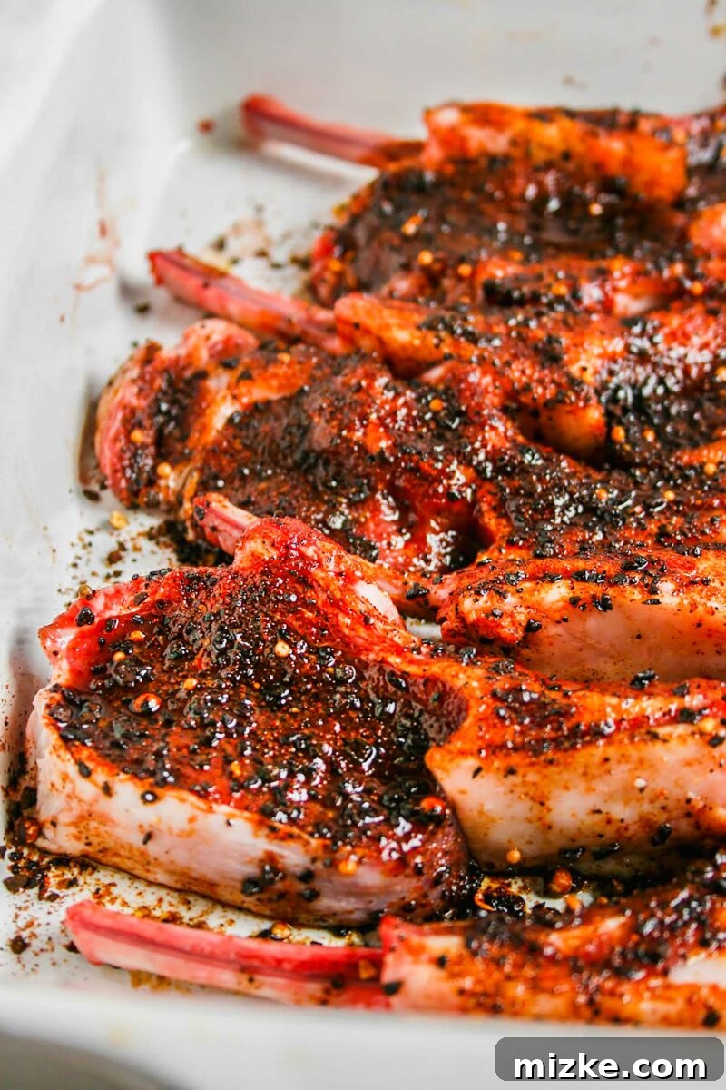 Smoky Coffee Rubbed Grilled Lamb Chops 3 A large white serving plate is filled with multiple perfectly cooked coffee rubbed lamb chops, ready to serve.