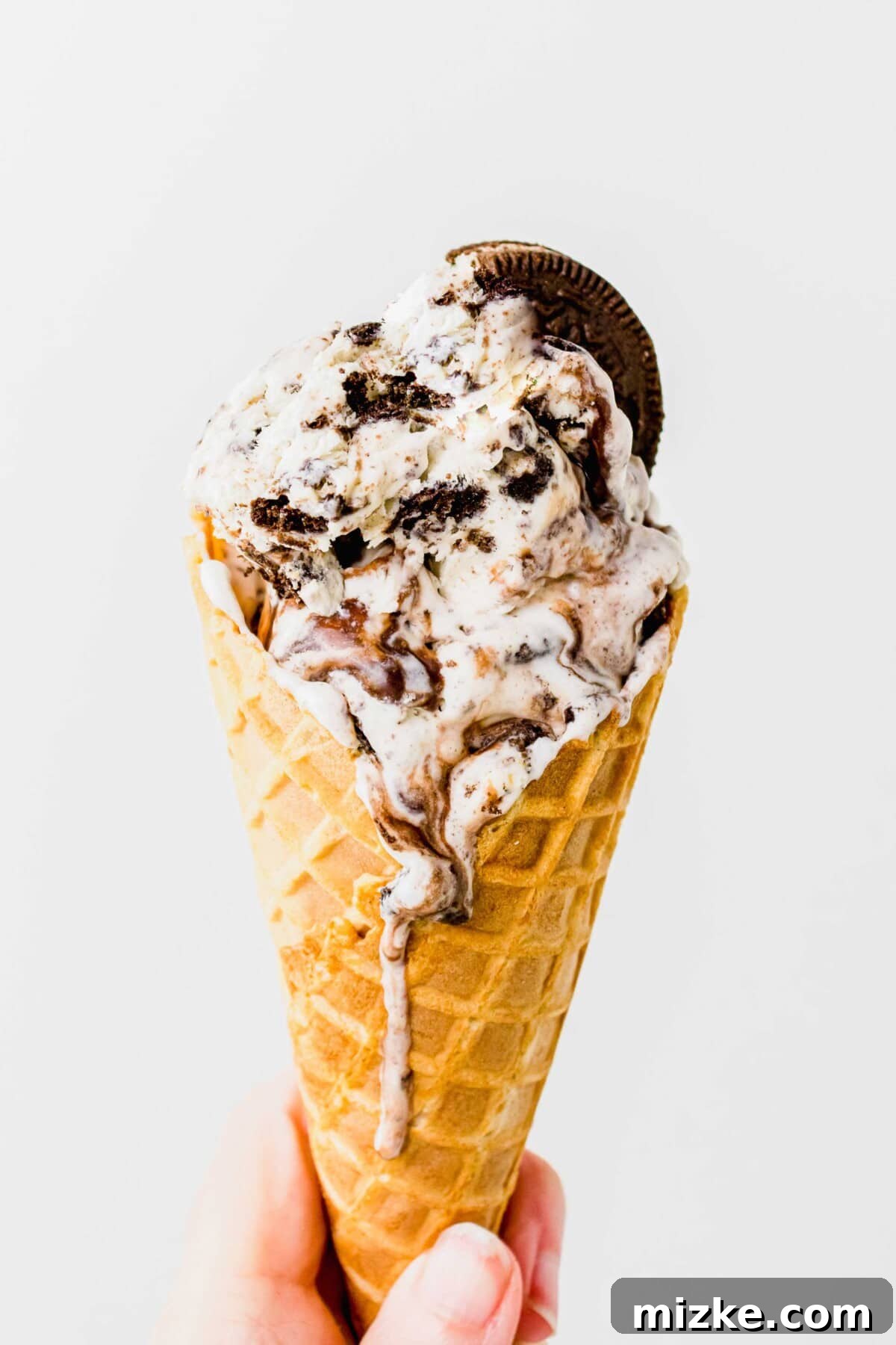 Oreo Cookie Bliss 10 A perfectly scooped cone of Oreo ice cream, slightly melting, inviting a delicious taste.