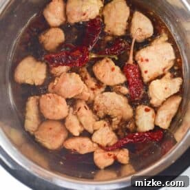 Chicken added to the sauce in the insert of an Instant Pot