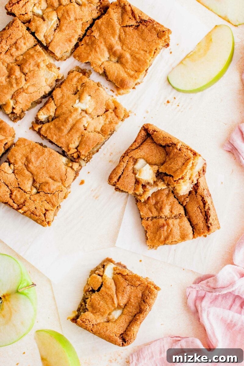 Spiced Apple Blondies 5 Blondie slices are spread out across parchment paper.
