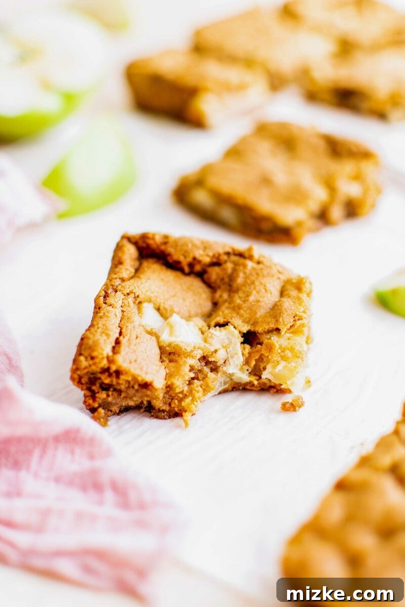 Spiced Apple Blondies 6 A blondie has had a bite taken out of it.