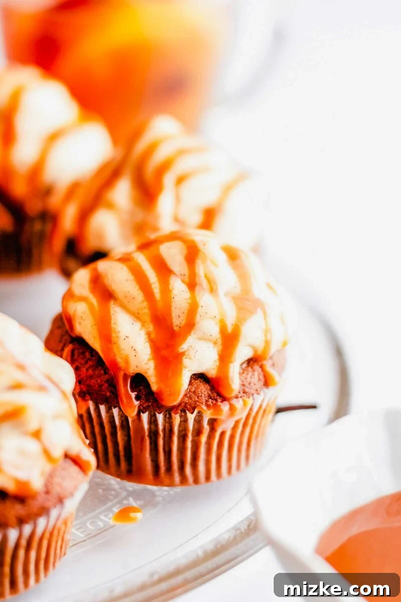 A cupcake is frosted and drizzled with salted caramel sauce.