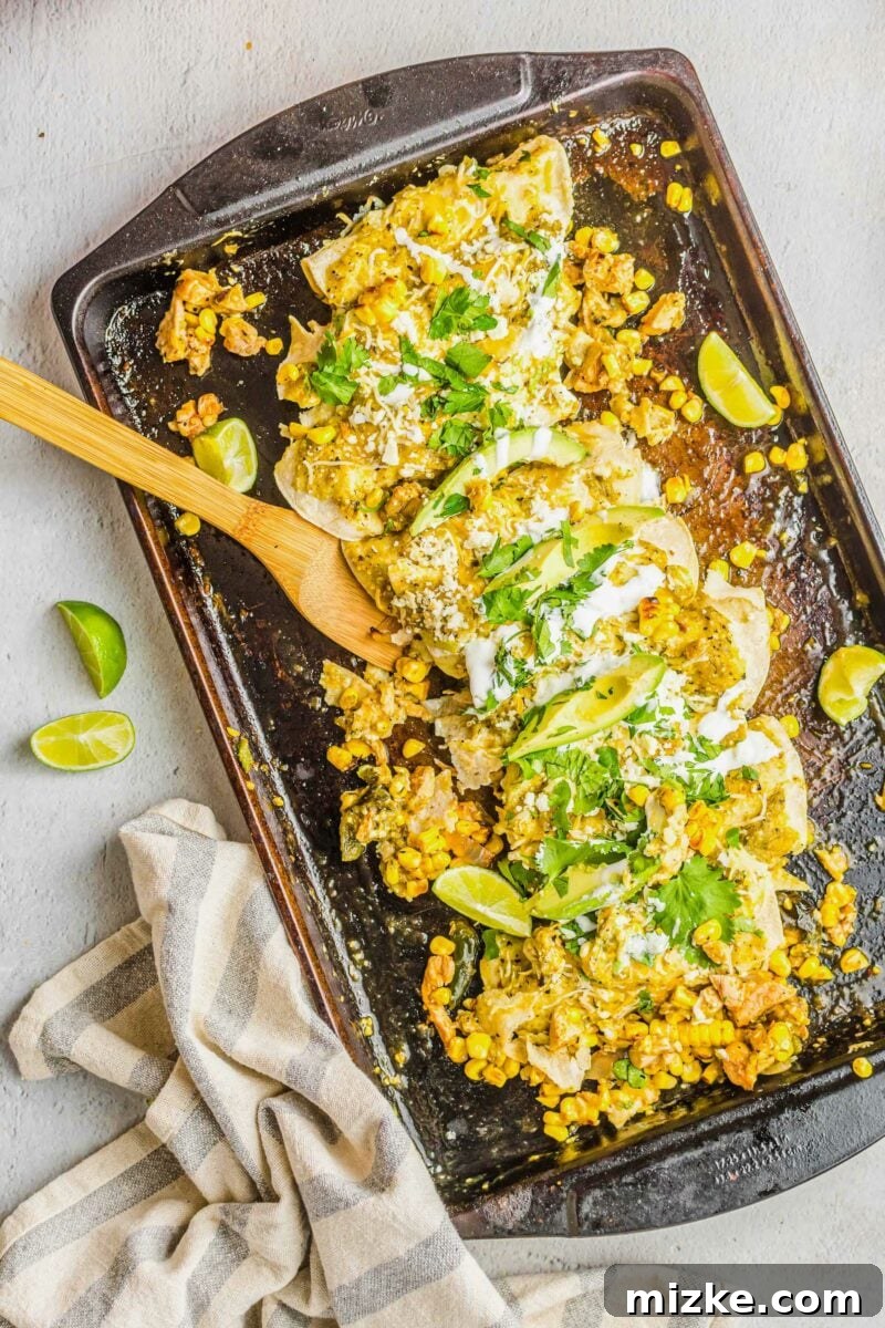 One-Pan Smoky Chipotle Chicken Enchiladas 2 Garnished sheet pan enchiladas with fresh cilantro, creamy avocado slices, and a dollop of sour cream, ready to serve.