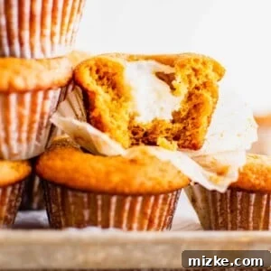 Velvet Pumpkin Cream Cheese Muffins 2 A close-up of a freshly baked pumpkin cream cheese muffin, showcasing its golden-brown top and delightful texture.