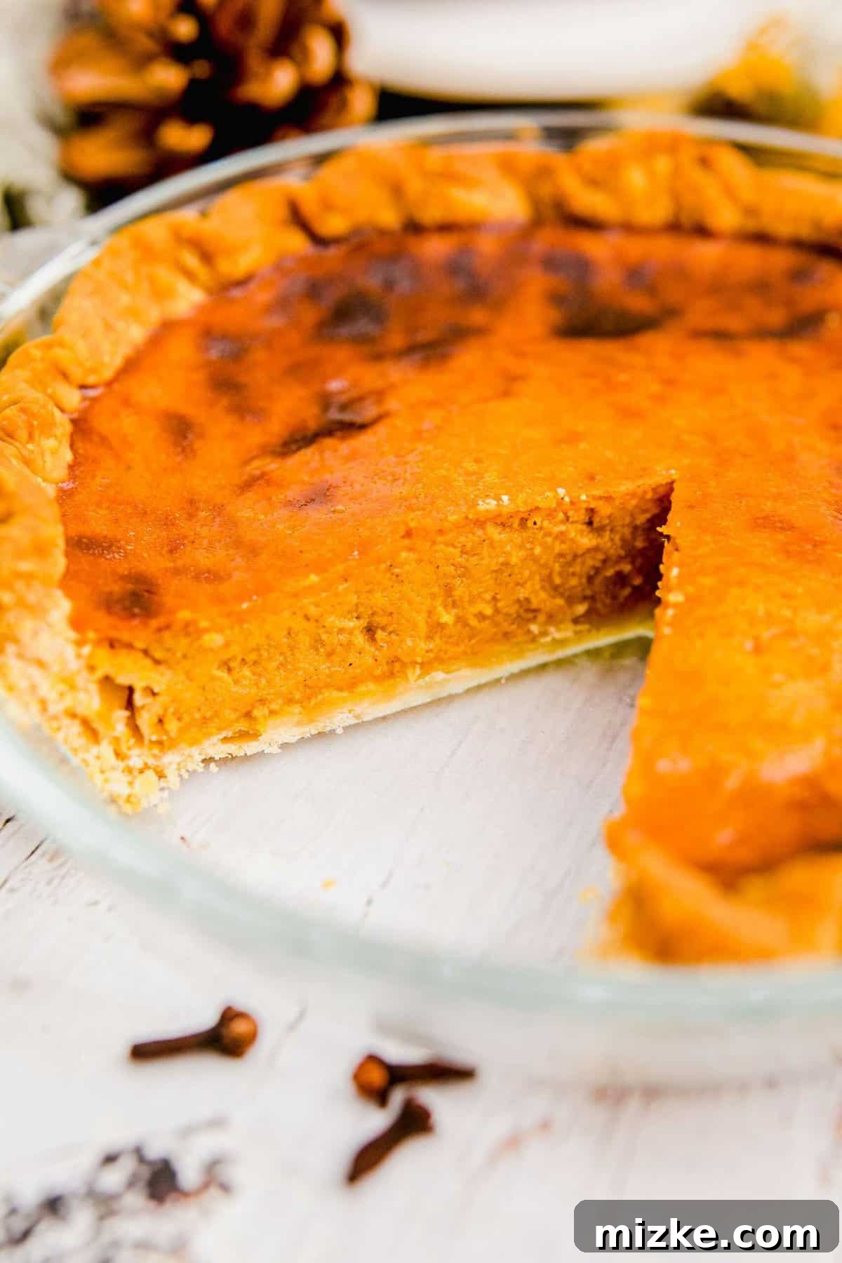 Perfect Slice of Air Fryer Pumpkin Pie A delicious slice of golden-brown pumpkin pie has been expertly removed from its baking dish.