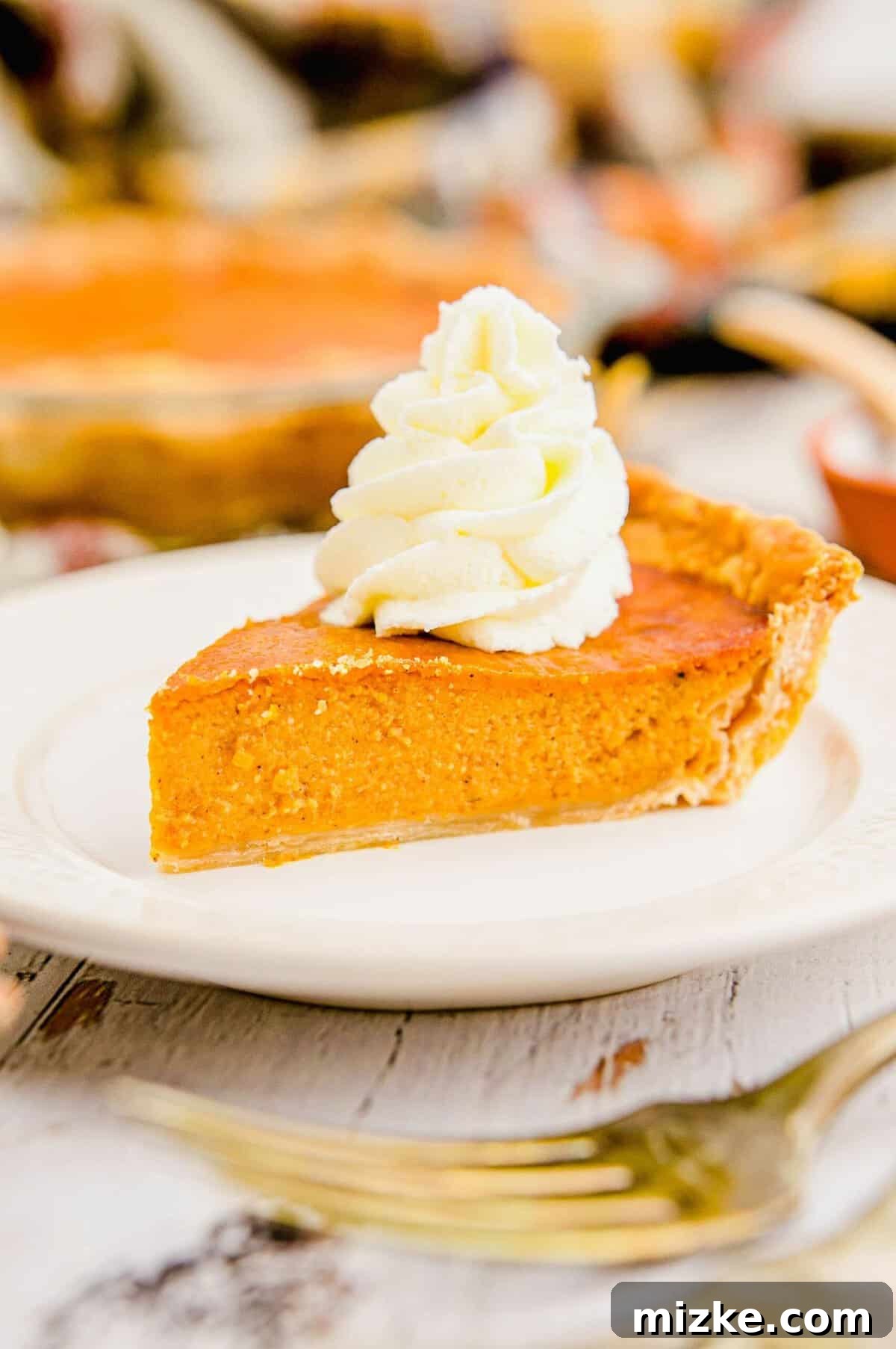 Whipped Cream on Pumpkin Pie A luscious swirl of fluffy white whipped cream crowning a golden-brown slice of pumpkin pie.