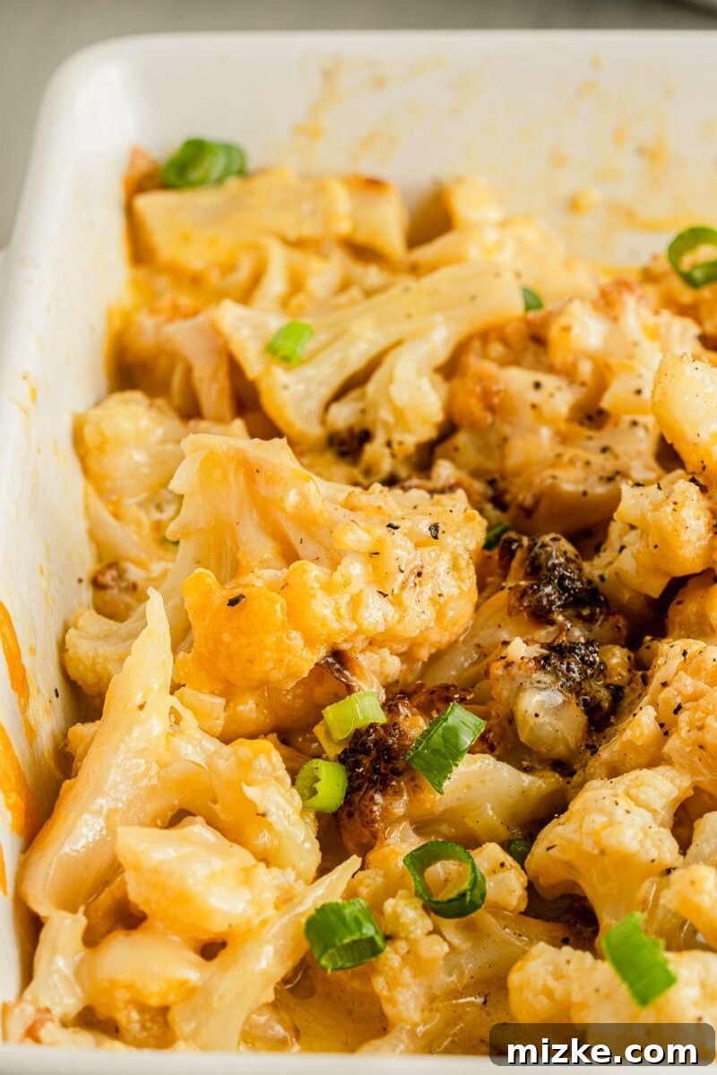 Golden Baked Cheesy Cauliflower Delight 4 Green onions are placed on top of baked cauliflower.