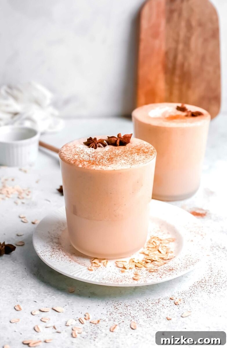 Autumn Pumpkin Bliss 4 Two glasses of pumpkin pie smoothie are placed next to each other on a white surface.