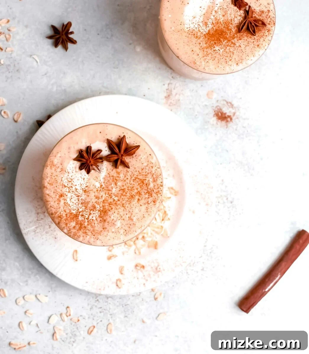 Autumn Pumpkin Bliss 5 Oats and cinnamon sticks are placed next to cups of pumpkin pie smoothie.