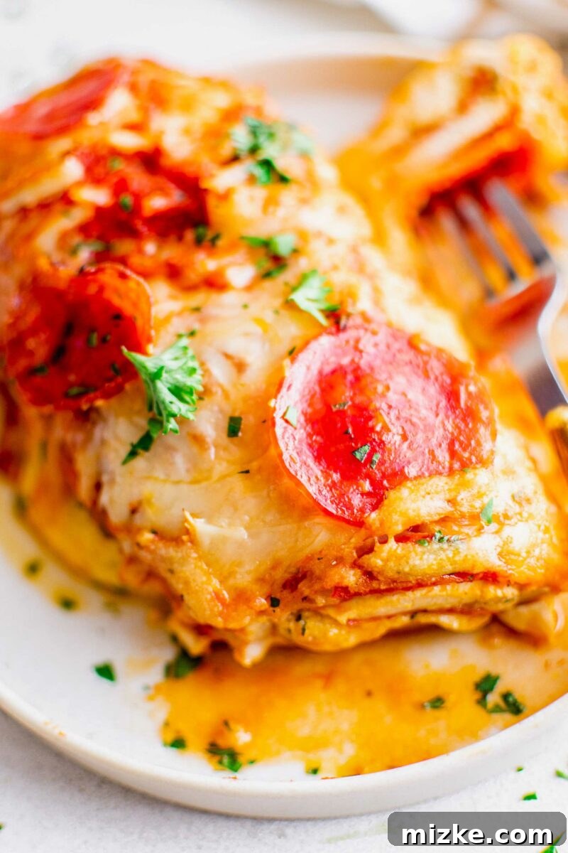 Pizza Bomb Chicken 5 A piece of chicken is fully cooked with pepperoni, cheese, and parsley on top.