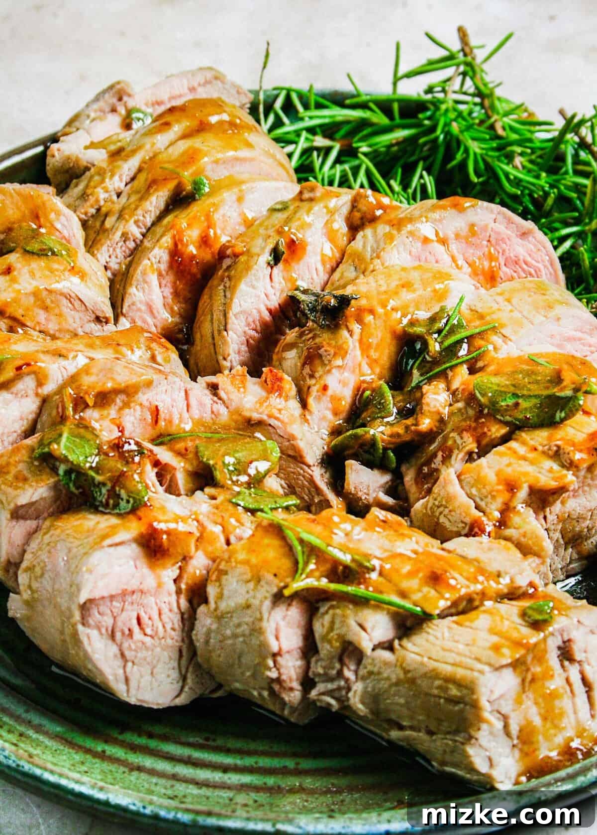 Maple-Glazed Mustard Pork Tenderloin 3 A sliced pork tenderloin is topped with fresh herbs and glaze.