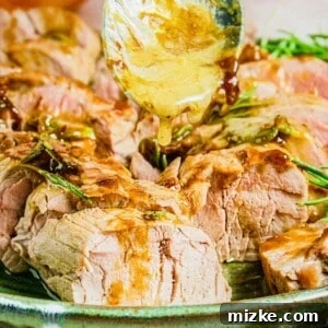 A spoon is drizzling golden brown glaze on a piece of pork.