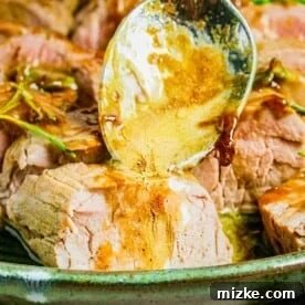 Glaze is being drizzled atop a serving of sliced pork tenderloin.