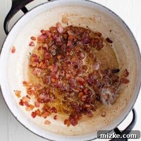 Spicy Cajun Shrimp Skillet Pasta 5 cooked, crispy bacon pieces in a pan