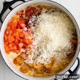 Spicy Cajun Shrimp Skillet Pasta 8 tomatoes, bacon, shrimp parmesan cheese, and heavy cream in a pot with cooked linguine noodles