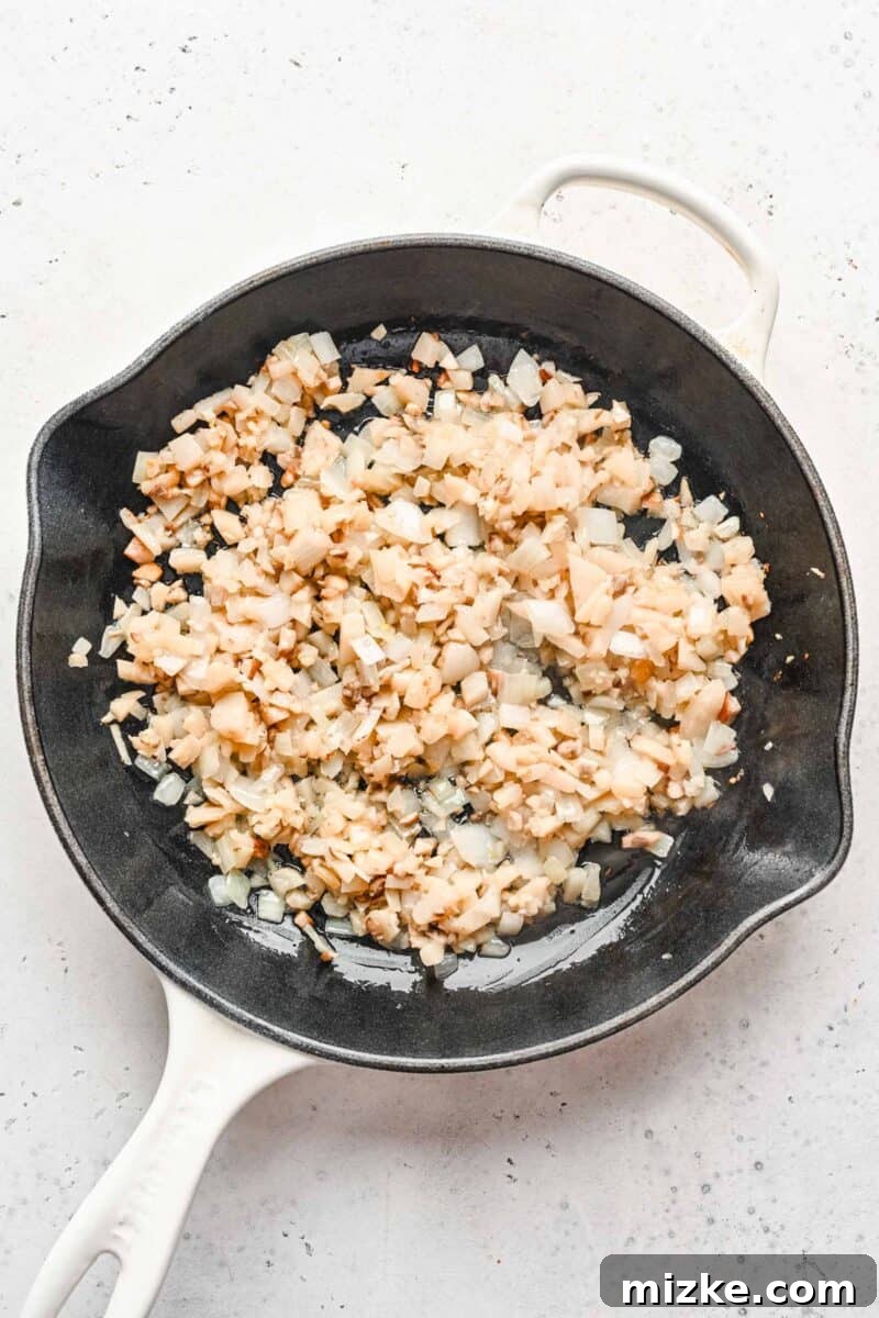 These chicken lettuce wraps are made with crisp lettuce, juicy ground chicken, tender shiitake mushrooms, and a sweet and tangy sauce! A skillet filled with diced shiitake mushrooms, water chestnuts, and onions, sautéing to perfection.