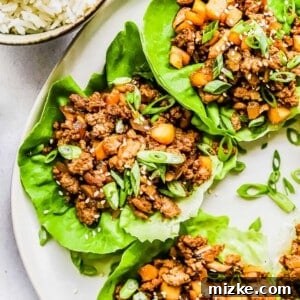 Chicken lettuce wraps garnished with green onions.