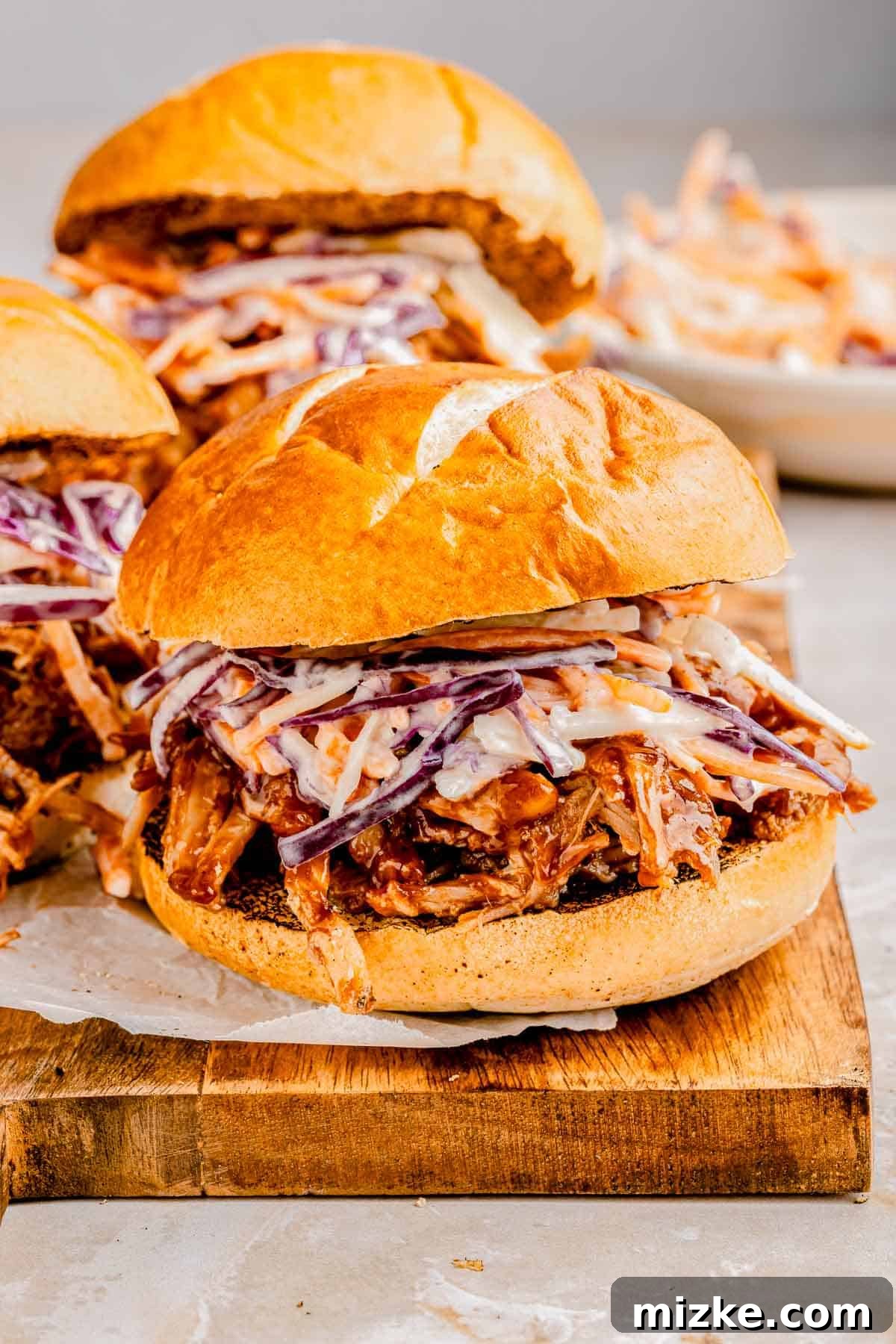 Slow-cooked pork in soda, shredded, and generously tossed in BBQ sauce for the ultimate party appetizer. Delicious BBQ pulled pork sliders topped with fresh slaw, ready to be served.