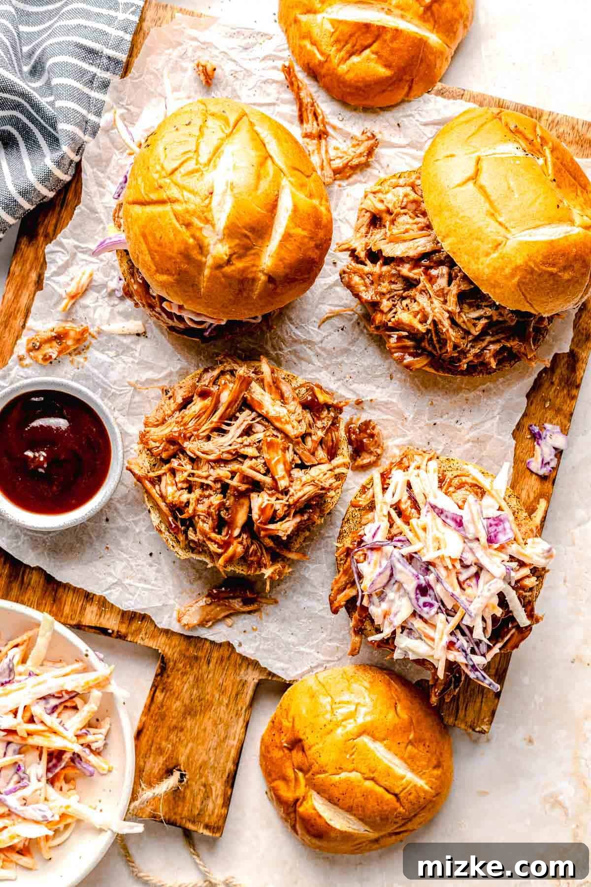 Perfectly presented BBQ pulled pork sliders, ready to impress your guests. Overhead view of an artfully arranged serving board with BBQ pulled pork sliders. One slider is open to reveal the juicy pulled pork inside.