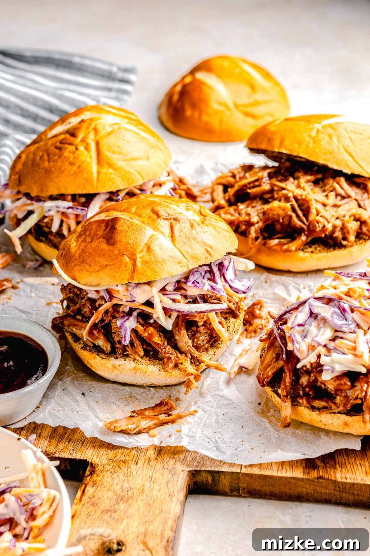 The perfect party platter: pulled pork sliders with fresh slaw. A rustic wooden board brimming with BBQ pulled pork sliders, each topped with a vibrant coleslaw.
