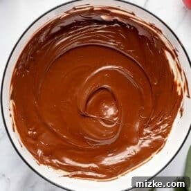 Smooth, melted chocolate in a bowl, perfectly prepared for topping the caramel layer