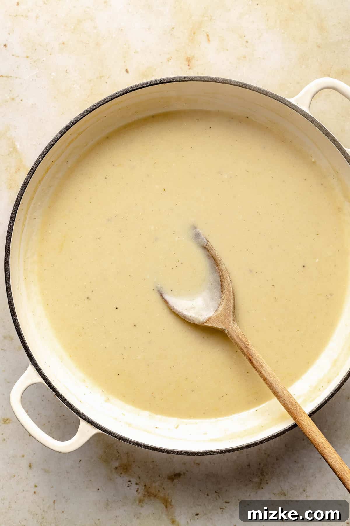 Rich and creamy homemade Alfredo sauce in a pan. A creamy, bubbling Alfredo sauce simmering in a large skillet, ready for the addition of pasta and protein.