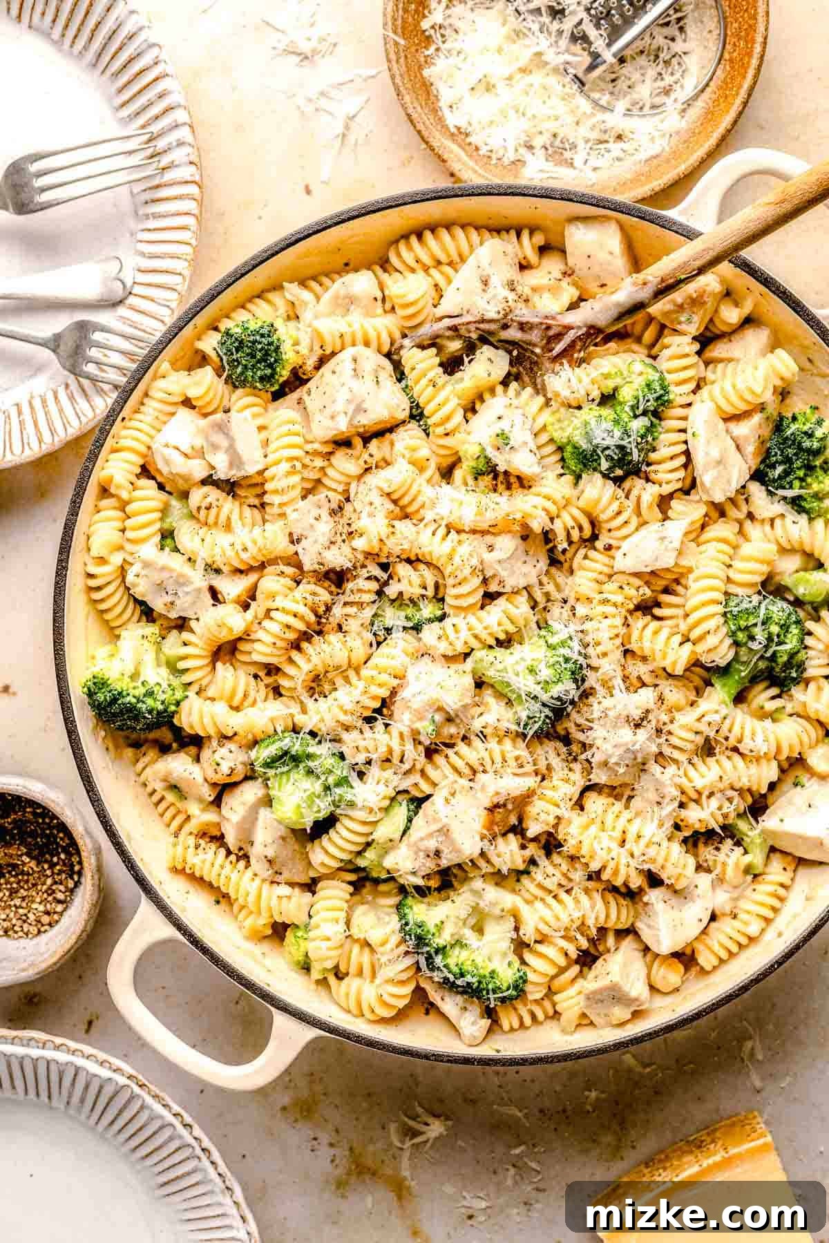 Finished Chicken Broccoli Alfredo pasta dish in a skillet, showcasing the rich sauce and ingredients. An overhead view of Chicken Broccoli Alfredo pasta simmering in a large skillet, perfectly coated in a creamy sauce.
