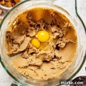 creamed butter and sugars with 2 egg yolks on top in a glass stand mixer bowl