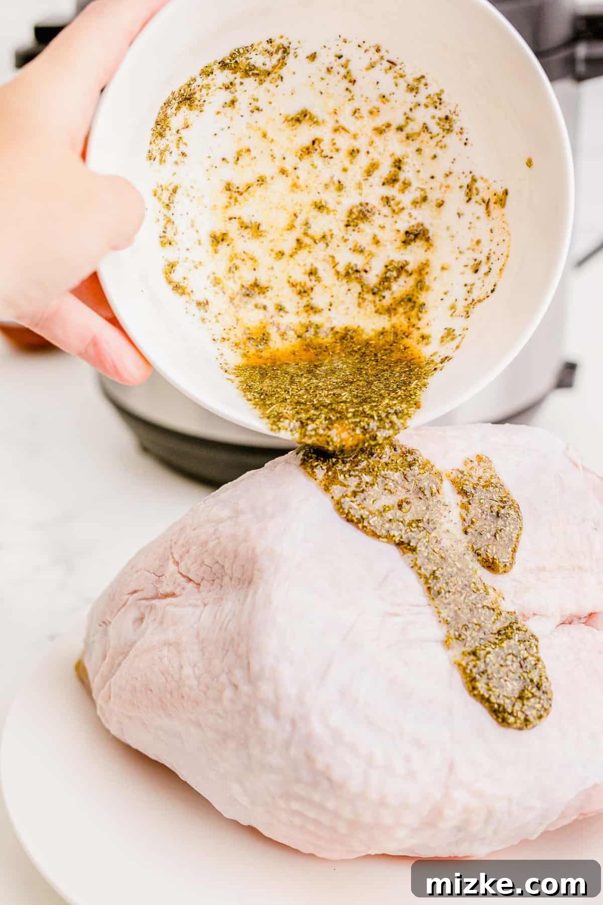 Perfect Instant Pot Turkey Breast 5 Applying a savory spice rub to a turkey breast with olive oil, ensuring even coating for maximum flavor.