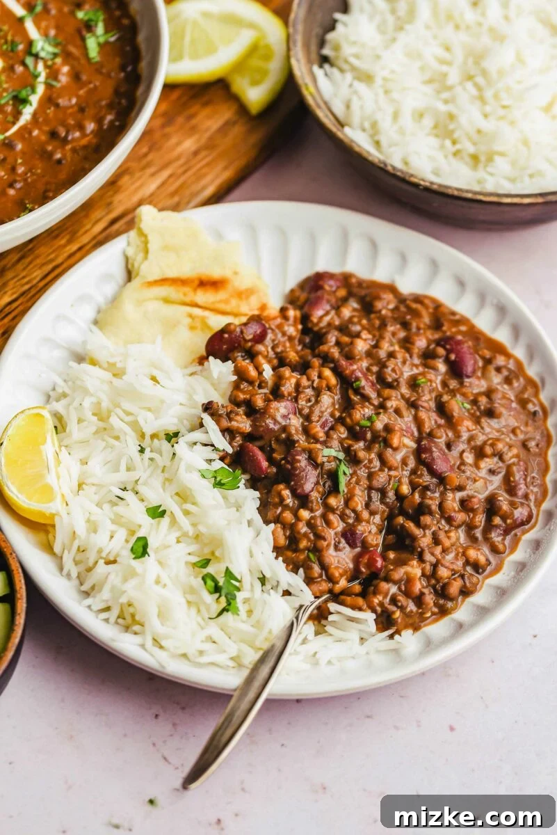 Rice, dal makhani, and naan are placed on a white plate.